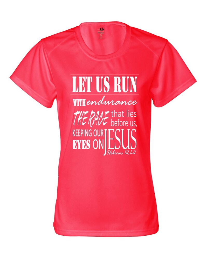 May include: A bright pink athletic t-shirt with a white graphic that reads "Let us run with endurance the race that lies before us, keeping our eyes on Jesus, Hebrews 12:12".