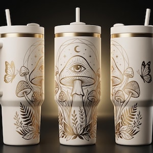 Puede incluir: Taza de viaje blanquecina con tapa, asa y detalles dorados. La taza presenta una ilustración dorada de setas, mariposas y elementos celestiales. Incluye una pajita blanca.