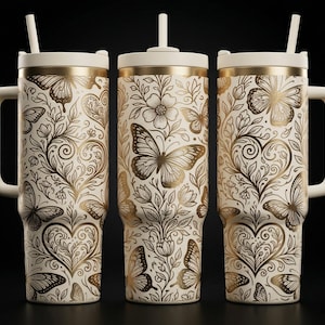 Puede incluir: Tres vasos de color crema con asas y pajitas, con un patrón metálico dorado de mariposas y corazones florales. El diseño incluye intrincados dibujos de líneas de mariposas, flores en flor y formas de corazones en espiral sobre un fondo claro.