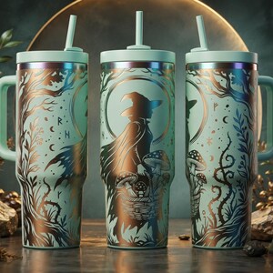 May include: Three light green tumblers with handles and straws, featuring a metallic copper-toned illustration of a witch in a cloak holding a basket of mushrooms, surrounded by trees, crescent moons, and stars against a circular backdrop.