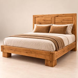 May include: A wooden bed frame with a natural grain finish and a tall rectangular headboard. The bed is dressed with a white duvet, two brown rectangular pillows, and a textured brown throw blanket draped across the foot of the mattress.