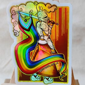 May include: A sticker featuring a knight in shining armor holding a sword and a rainbow flag. The knight is depicted with a helmet and armor, and the flag flows behind them. The sticker has a holographic effect and the text "@reverie_art_k".