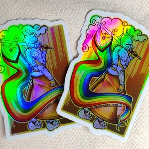 May include: Two holographic stickers featuring a knight in armor holding a sword and a rainbow flag. The knight is depicted with a rainbow-colored cape and a cloud-like design above. The stickers have a gold and brown background with the text "@REVERSECOL_ART_K".