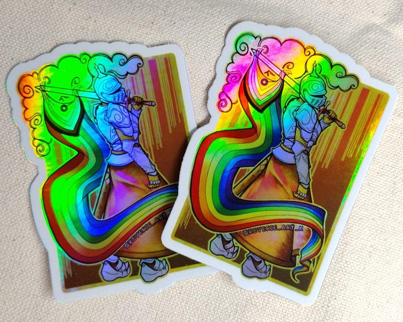 May include: Two holographic stickers featuring a knight in armor holding a sword and a rainbow flag. The knight is depicted with a rainbow-colored cape and a cloud-like design above. The stickers have a gold and brown background with the text "@REVERSECOL_ART_K".