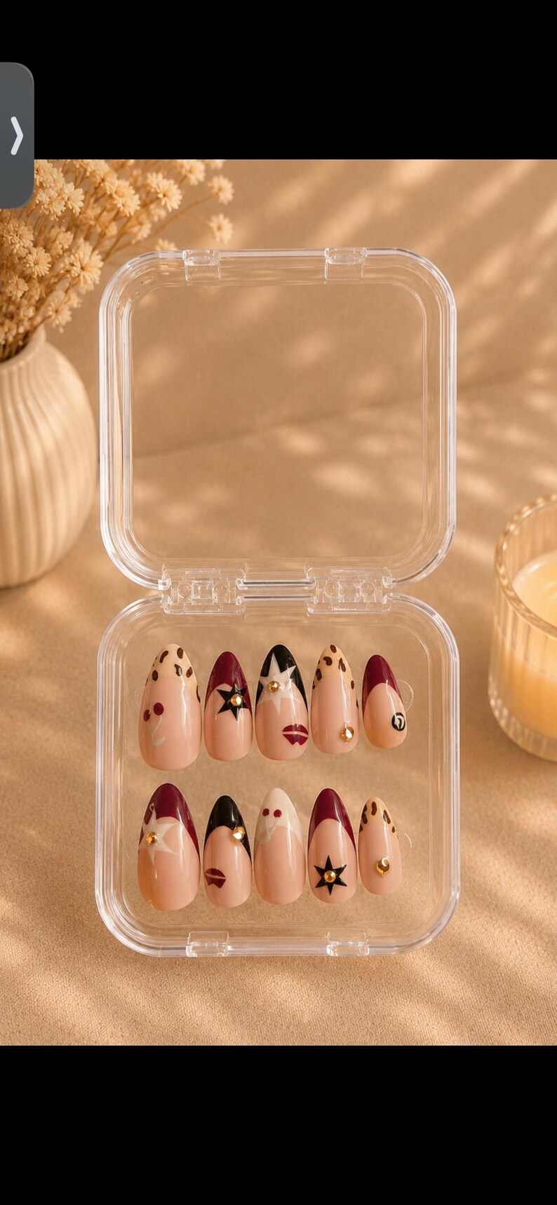 Pu&ograve; includere: Un set di unghie finte a forma di mandorla in una custodia di plastica trasparente. Le unghie sono decorate con vari disegni, tra cui pois, stelle e labbra, nelle tonalit&agrave; nude, bordeaux e nero. Alcune unghie hanno accenti dorati.