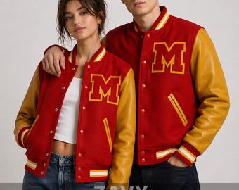 May include: Red and gold varsity jackets with the letter "M" on the chest. The jackets have red bodies, gold sleeves, and white and gold striped trim. The jackets are worn by two people. The brand name "ZAVY" is visible.