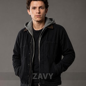 Op de afbeelding: Een zwart canvas jack met een bruine corduroy kraag, gedragen over een grijze hoodie en een zwart t-shirt. Het jack heeft een ritssluiting, twee borstzakken en twee zijzakken. Het woord ZAVY is zichtbaar op de afbeelding.