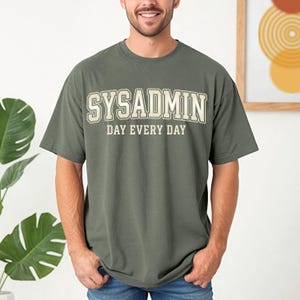 Könnte beinhalten: Set aus drei Keramikbechern mit gesprenkelter, matter Oberfläche. Die Becher sind in Creme-, Hellgrau- und Dunkelgrautönen gehalten. Jede Tasse hat ein schlichtes, minimalistisches Design.