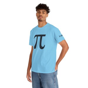 May include: Light blue t-shirt featuring a large black Pi symbol on the front. The text "I am" is printed on the right sleeve. The shirt is made of a soft material.