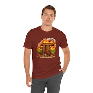 May include: A maroon t-shirt featuring a graphic of the mathematical symbol Pi engulfed in flames. The design includes a tree-like base and surrounding foliage. The shirt is worn by a person.