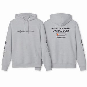 May include: Light gray hoodie with a front pocket and hood. The front features a black line design. The back displays the text "ANALOG SOUL DIGITAL BODY" above a low battery graphic and the question "Are we ready?" The sleeves have a black design.