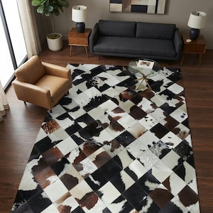 May include: A large rectangular area rug featuring a patchwork design of square cowhide tiles in a diamond orientation. The tiles display a mix of natural black, white, and brown fur patterns, creating a high-contrast geometric floor covering.