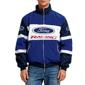 Könnte beinhalten: Eine blau-weiß-dunkelblaue Reißverschlussjacke mit Stehkragen und langen Ärmeln. Auf der Brust befindet sich ein blau-weißes Ford-Logo, darunter das Wort RACING in roter Schrift. Die Ärmel sind zudem mit kleinen Ford-Logo-Aufnähern versehen.