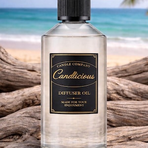 May include: A clear glass bottle of diffuser oil with a black cap. The label reads "Candlicious" and "Diffuser Oil" with the text "Made for your enjoyment". The background shows a beach scene.