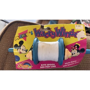 May include: Vintage Mickey's Wacky Winder kite spool. The kite spool is blue with a white string and a yellow and pink cardboard backing. The packaging features Mickey and Minnie Mouse.