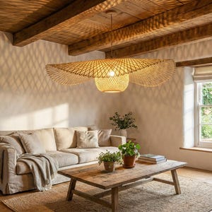 Könnte beinhalten: Ein Wohnzimmer mit natürlicher, rustikaler Ästhetik. Eine große, gewebte Pendelleuchte hängt über einem beigefarbenen Ecksofa, einem Holztisch und einem Jute-Teppich. Ein Fenster bietet einen Blick auf einen üppigen Garten.