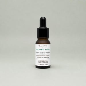 May include: A small, brown glass bottle of Olara Naturals Breathe Shield essential oil. The label lists ingredients like peppermint and rosemary. The bottle has a black dropper top and contains 0.34 fl oz / 10 ml.