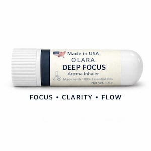 May include: A white and navy blue aroma inhaler with the text "DEEP FOCUS" and "Made in USA". The inhaler has a white cap and a rounded end. The text "FOCUS • CLARITY • FLOW" is printed below the inhaler.
