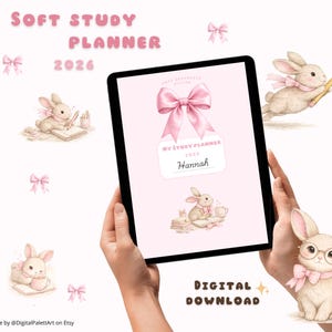以下が含まれることがあります： 手で持たれた2026年のデジタルスタディプランナー。プランナーは、大きなリボンと「My Study Planner 2026 Hannah」というテキストが入ったピンク色の表紙です。画像にはウサギとリボンのイラストが含まれています。「Soft Study Planner 2026」と「Digital Download」というテキストがあります。