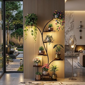 May include: A tall, dark metal plant stand with multiple tiered shelves and integrated LED lighting. The stand holds various potted plants, including trailing vines, succulents, and flowering plants in metallic and ceramic pots.