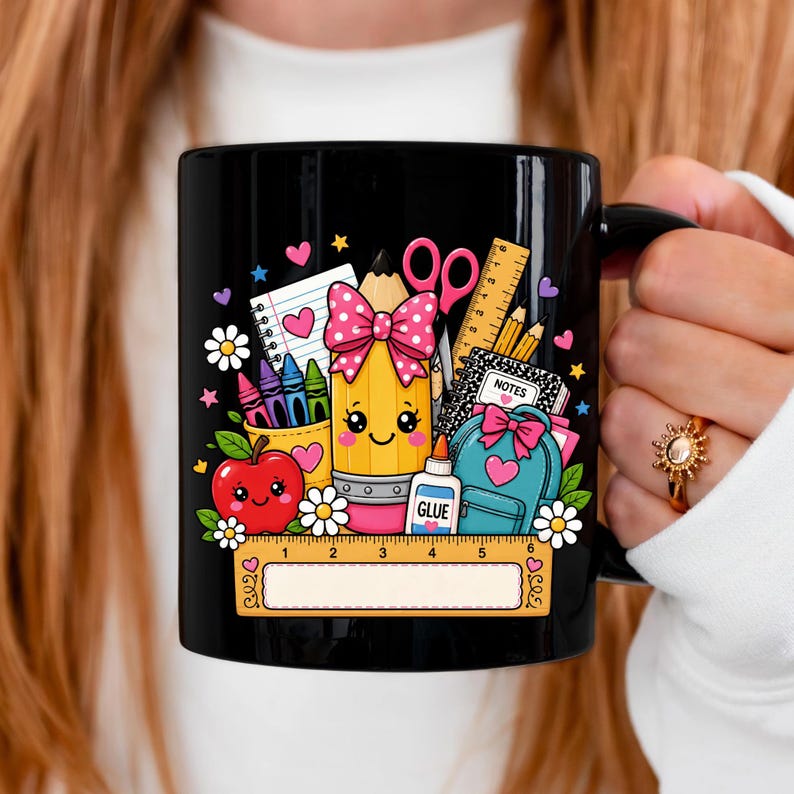 May include: A black ceramic mug featuring a colorful graphic of school supplies including a smiling pencil with a pink polka dot bow, a red apple, a blue backpack, scissors, glue, crayons, a notebook, and a ruler with markings in inches.