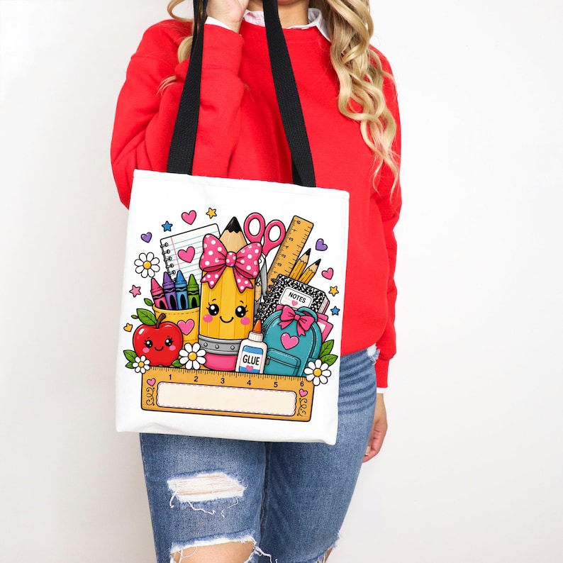 May include: A white tote bag with black straps featuring a colorful graphic of school supplies including a smiling pencil with a pink polka dot bow, a red apple, a blue backpack, a ruler, glue, and notebooks, all decorated with small hearts and flowers.