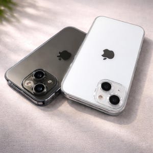 Può includere: Sono mostrati due smartphone, uno grigio e uno bianco. Entrambi i telefoni hanno una custodia protettiva trasparente e il logo Apple. Il telefono grigio è angolato, rivelando le lenti della fotocamera. Il telefono bianco è posizionato per mostrare il retro.