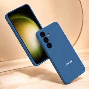 May include: A blue phone case and a smartphone with a green and yellow screen. The phone case has three camera cutouts and the word "SAMSUNG" printed on the back. The phone is angled to show the screen.