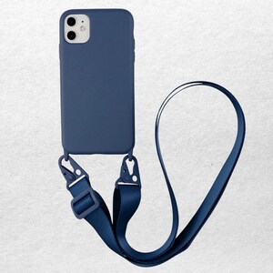 May include: A navy blue phone case with a matching lanyard. The case is attached to a navy blue strap with adjustable buckles and metal clasps. The phone case is designed to fit a smartphone.