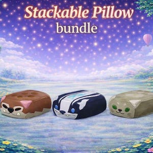 May include: Three stackable pillows featuring animal designs: a brown bear, a black and white skunk, and a green cat. The pillows are set on a floral meadow with a starry sky. Text reads "Stackable Pillow bundle".