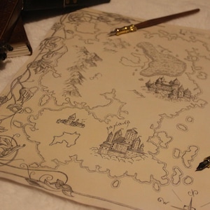 May include: A detailed hand-drawn map featuring castles, islands, and a floral border. Two quill pens with gold accents and a leather-bound journal are also visible. The map is on cream-coloured paper.