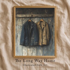 May include: Framed artwork featuring two jackets hanging on a wooden wall. One jacket is navy blue, the other is tan. The artwork is titled "The Long Way Home" and is labeled "Illustrated Folk Art". The frame is gold.