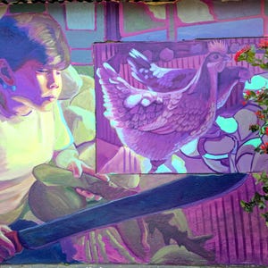 May include: A vibrant mural depicts a young person holding a machete, with a painted image of chickens in the background. The artwork is dominated by shades of purple, pink, and green, with a touch of red from the flowers on the right.