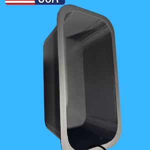 May include: A dark grey rectangular container with rounded corners, set against a blue background. The container has a textured edge and the words "MADE IN USA" are visible with the American flag. A graphic of a delivery truck is also present.