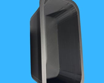 Op de afbeelding: Een donkergrijze rechthoekige container met afgeronde hoeken, tegen een blauwe achtergrond. De container heeft een getextureerde rand en de woorden "MADE IN USA" zijn zichtbaar met de Amerikaanse vlag. Een afbeelding van een bezorgwagen is ook aanwezig.