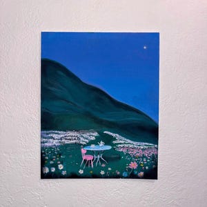 May include: Acrylic painting of a tranquil outdoor scene. A small round table with a teapot and cups sits beside a pink chair in a field of flowers. A dark green mountain rises under a deep blue sky with a single star.
