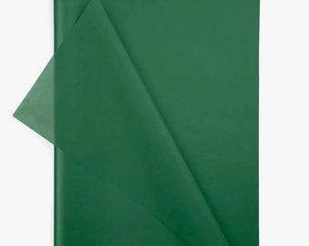 Puede incluir: Una hoja rectangular de papel de seda de color verde bosque oscuro. El papel es fino y semitranslúcido, con una esquina doblada que revela un tono de verde más claro y transparente donde el material se superpone sobre sí mismo.