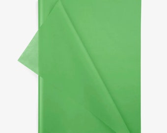 Puede incluir: Una hoja rectangular de papel de seda verde claro con una textura suave y semitranslúcida. El papel está doblado en la esquina superior izquierda, revelando un tono ligeramente más claro donde el material se superpone sobre la superficie.