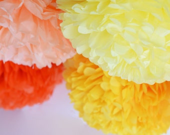 Différentes quantités de décorations de fête avec pompons en papier jaune et orange