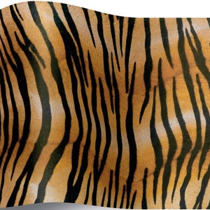 May include: A close-up of a tiger print fabric with orange and black stripes. The fabric has a slightly textured surface.