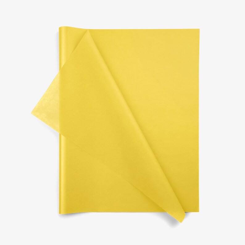 May include: A stack of rectangular yellow tissue paper sheets. The top sheet is partially folded over, revealing the thin, semi-translucent texture of the material. The paper has a smooth, matte finish and a vibrant, solid yellow color throughout.