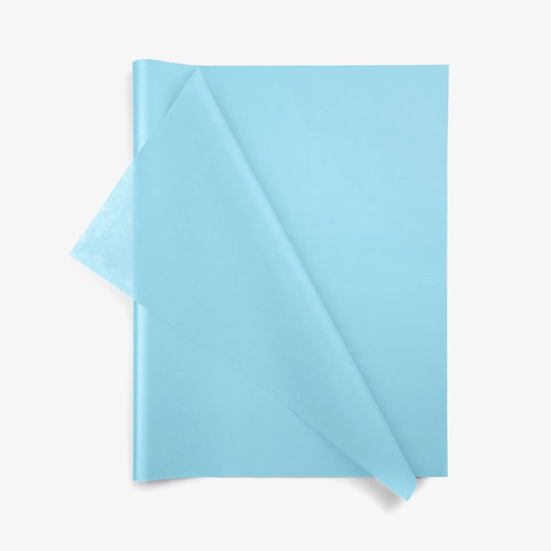 May include: A stack of light blue tissue paper sheets with a rectangular shape. The top sheet is folded over at the left corner, revealing the thin, semi-translucent texture of the paper. The color is a consistent, solid, pale sky blue hue.