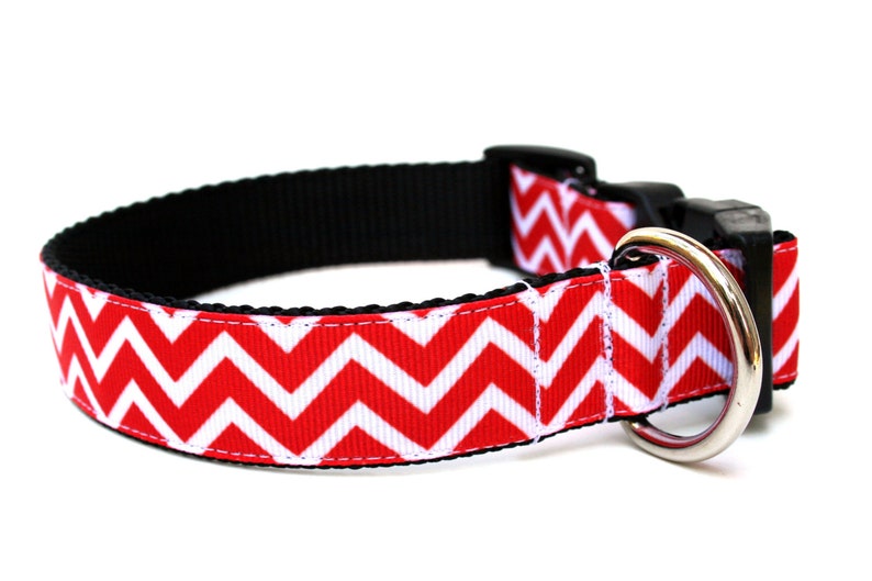 Puede incluir: Collar para perro con estampado de chevron rojo y blanco, hebilla negra y anilla en D plateada.