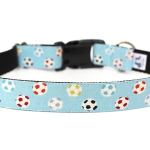 Peut inclure: Un collier pour chien bleu clair avec une boucle noire et un motif de ballons de football color&eacute;s.