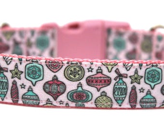 Puede incluir: Collar de perro rosa con fondo blanco y un patrón de adornos navideños coloridos.