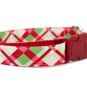 K&ouml;nnte beinhalten: Rotes, gr&uuml;nes und wei&szlig;es kariertes Hundehalsband mit einer roten Kunststoffschnalle.