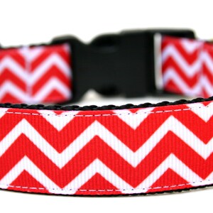 Puede incluir: Collar para perro con estampado de chevron rojo y blanco, hebilla negra y anilla en D de metal dorado.