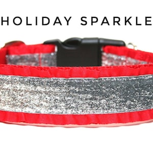 Peut inclure: Collier pour chien rouge avec un ruban argenté pailleté et une boucle noire. Le collier a un bord festonné. Le texte "HOLIDAY SPARKLE" est écrit au-dessus du collier.