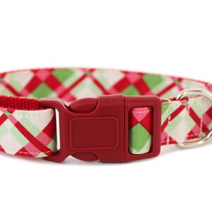 K&ouml;nnte beinhalten: Rotes, gr&uuml;nes und pinkfarbenes kariertes Hundehalsband mit einer roten Kunststoffschnalle und einem silbernen D-Ring.
