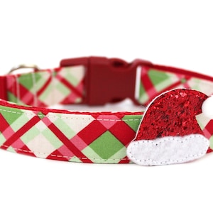 K&ouml;nnte beinhalten: Rotes, gr&uuml;nes und wei&szlig;es karierter Hundehalsband mit einem roten Glitzer-Weihnachtsmann-Hut-Anh&auml;nger.